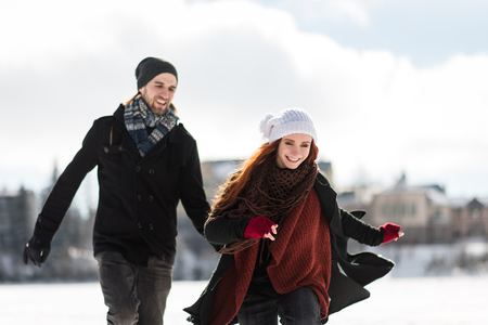 Cheerful young couple playing in snowy mountainsの写真素材