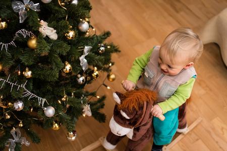 Baby boy riding on rocking horse toy, overhead shot.の写真素材