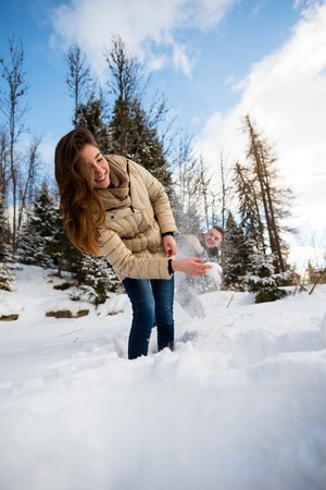Young playful couple enjoying in the snowの写真素材