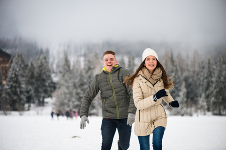 Playful teen couple playing in the snowの写真素材