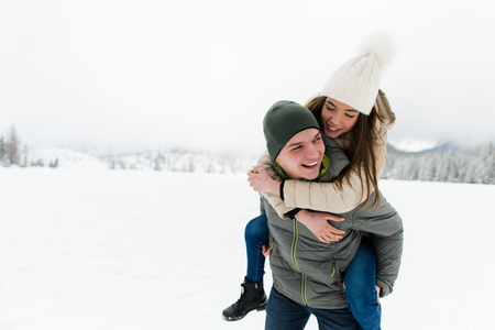 Romantic teen couple having fun in snowの写真素材