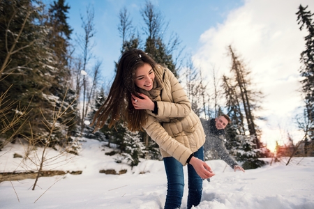 Cheerful couple playing outdoors at winter timeの写真素材