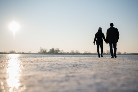 Romantic couple holding hands, landscape view.の写真素材