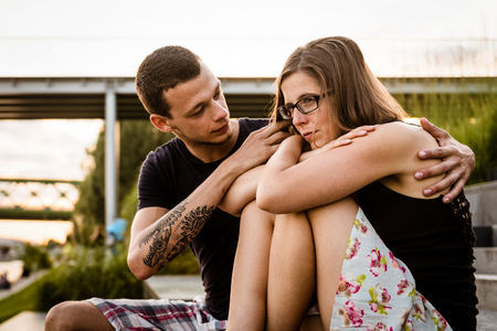 Upset woman with her loving boyfriendの写真素材