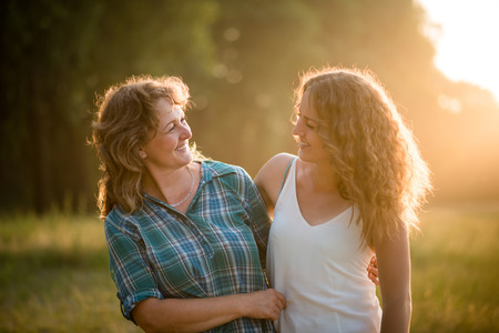 Pretty teenage daughter with her mother. Both facing each other.の写真素材