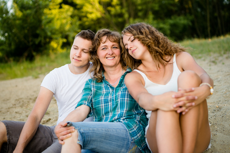 Carefree children resting their head on mothers shoulderの写真素材