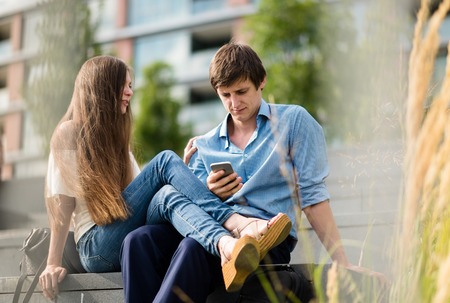 Young man is focused on using smartphoneの写真素材