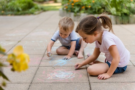 Children drawing with chalk outdoorsの写真素材