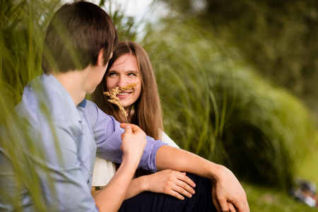 Young man and woman having fun in parkの写真素材
