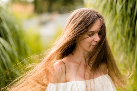 Attractive young woman waving her hair in parkの写真素材