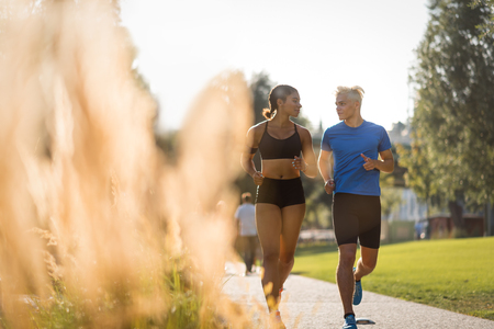 Fitness couple jogging on pathway in parkの写真素材
