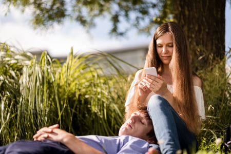 Young man sleeping on his girfriendss lapの写真素材