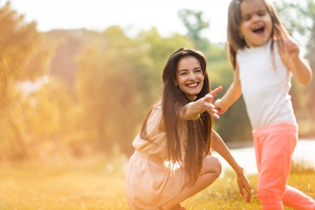 Woman trying to catch her girl childの写真素材