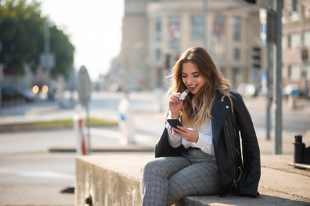 Woman sitting outside having a bite of chocolate barの写真素材