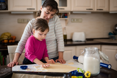 Mother with little daughter baking Christmas cookiesの写真素材