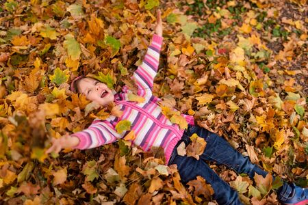 Kid enjoying her day out in an autumn parkの写真素材
