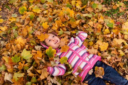 Girl child enjoying autumn season outdoorsの写真素材