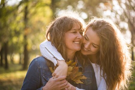 Daughter hugging her mother - autumn seasonの写真素材