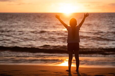 Child enjoying the freedom of sunset and seaの写真素材