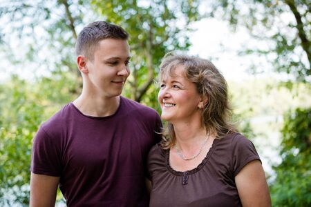 Cheerful mother with adult son outdoors. Family concept.の写真素材