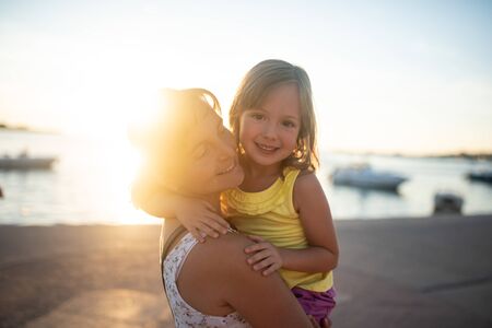 Mother carrying cute daughter in her armsの写真素材