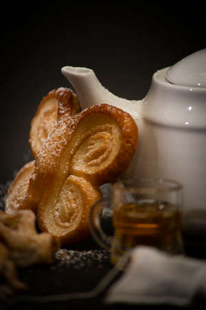 sweet breakfast with green tea in a white teapot and tasty handmade cake with jam and covered with...