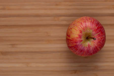One fresh red apple on a wooden background. Fresh and healthy breakfast fruit
