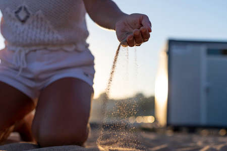 Beautiful Vietnamese woman alone playing and relaxing on the beach. Asian woman on holiday in a luxury resort in Portugal traveling alone around the world. Woman's lifestyle concept of freedomの写真素材