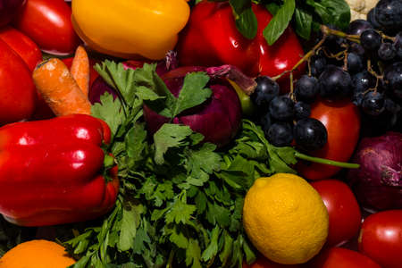 Background of vegetables different fresh farm vegetables. Food or Healthy diet concept, top view and light effects. Composition with assorted raw organic vegetables. detox diet: lemon, tomato, pepper, cauliflower, apple, grapeの写真素材