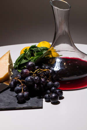 Minimal food composition of wine, grape and parmigiano (italian cheese) on a white background. Fresh...