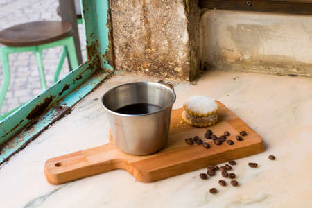 Italian black coffee in a cup with coffee beans and a handmade cookie with sugar and a Moka pot...