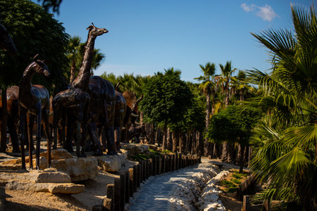 Lisbon, Portugal: 09/08/2020: Hiding part of the Buddha Garden with the african and wild animals sculptures (crocodile, giraffe, snake, monkey) in brass material. BacalhÃ´a Buddha Eden, asian style garden.のeditorial素材
