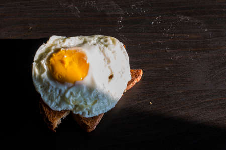 Homemade meal, Organic tasty cooked eggs for healthy breakfast on wood dark background and flowers in a vintage artistic composition. Simple food composition.の写真素材