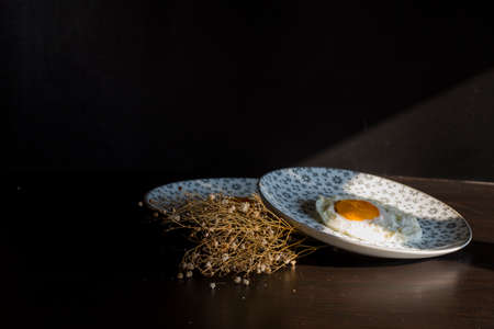 Homemade meal, Organic tasty cooked eggs for healthy breakfast on wood dark background and flowers in a vintage artistic composition. Simple food composition.の写真素材