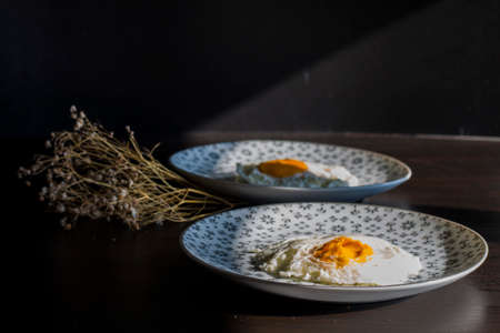 Homemade meal, Organic tasty cooked eggs for healthy breakfast on wood dark background and flowers...