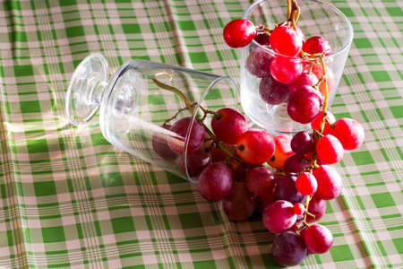 Red grapes, large bunch of fruits, fresh and tasty simple food with brights red and violet colors on...