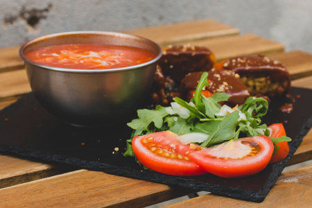 American fast food. A couple of beef and chicken skewers with a delicious peanuts sauce with some fresh salad with tomatoes and crunchy french fries. Delicious meat steaks on a wooden background.の写真素材