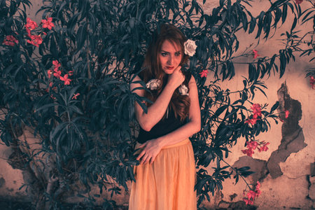 Portrait of young tender redhead young girl with healthy freckled skin wearing black top posing with serious or pensive expression. Caucasian woman model with ginger hair posing outdoors.の写真素材