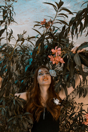 Portrait of young tender redhead young girl with healthy freckled skin wearing black top posing with serious or pensive expression. Caucasian woman model with ginger hair posing outdoors.の写真素材