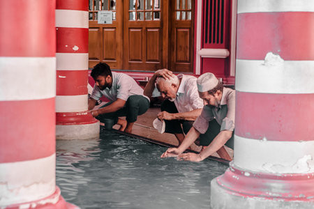 COLOMBO, SRI LANKA - 03-04-2019 : The decorative red-and-white facade of Jamiul Alfar Mosque, Red Mosque, in the oldest districts in Colombo, people stay around praying and spending their daily life.のeditorial素材