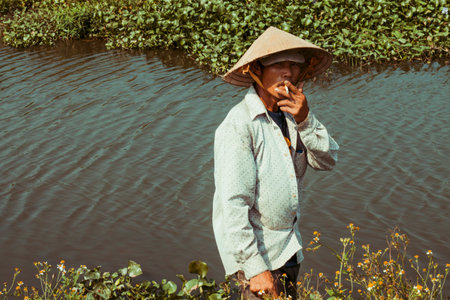 Phu Yen, Vietnam, 09-03-2018, Farmers on the way to work throug paddy fields in rural countryside Vietnam. Rice production in Vietnam in the Mekong and Red River deltas is important to the food supplyのeditorial素材