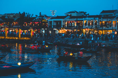 Hoi An, Vietnam - 09-04-2018: Colorful view of busy street and crowded river in Hoi An, Vietnam, famous for mixed cultures and architecture. Traditional colorful lanterns spread light all around.のeditorial素材
