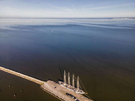 Aerial view of a four-mast sailing vessel docked at Lisbon marina harbour along Tagus river, Lisbon,...
