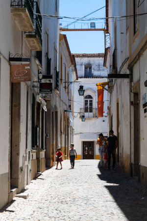 Evora, Portugal: 09/05/2021: Street view with beautiful old residential buildings in Evora city in Portugal with people around making their daily lifeのeditorial素材