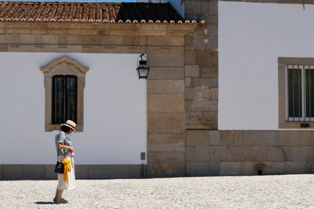 Evora, Portugal: 09/05/2021: Street view with beautiful old residential buildings in Evora city in Portugal with people around making their daily lifeのeditorial素材