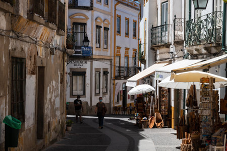 Evora, Portugal: 09/05/2021: Street view with beautiful old residential buildings in Evora city in Portugal with people around making their daily lifeのeditorial素材