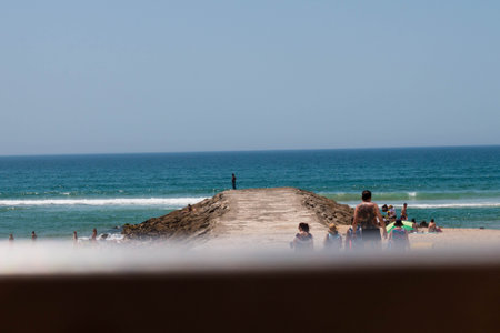 Caparica, Portugal: 09/05/2020: A mesmerizing view of a sandy beach with a lot of people in relax in Caparica, Portugalのeditorial素材