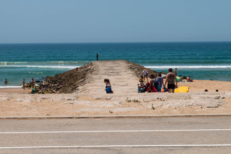 Caparica, Portugal: 09/05/2020: A mesmerizing view of a sandy beach with a lot of people in relax in Caparica, Portugalのeditorial素材