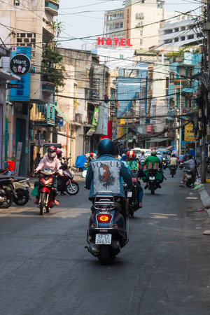 Ho Chi Minh city, Vietnam - 7 Feb 2021: people walking in teh city center of Ho chi Minh, Vietnam, people in the crowd streets with motorbyke, shops and parksのeditorial素材