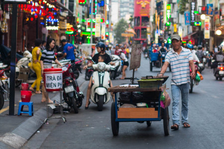 Ho Chi Minh City, Vietnam - 08-06-2019: colorful perspective of Bui Vien Street with numerous hotel, bar and shop sign boards, crowded with people & motorbikes with a view of Bitexco Financial Towerのeditorial素材